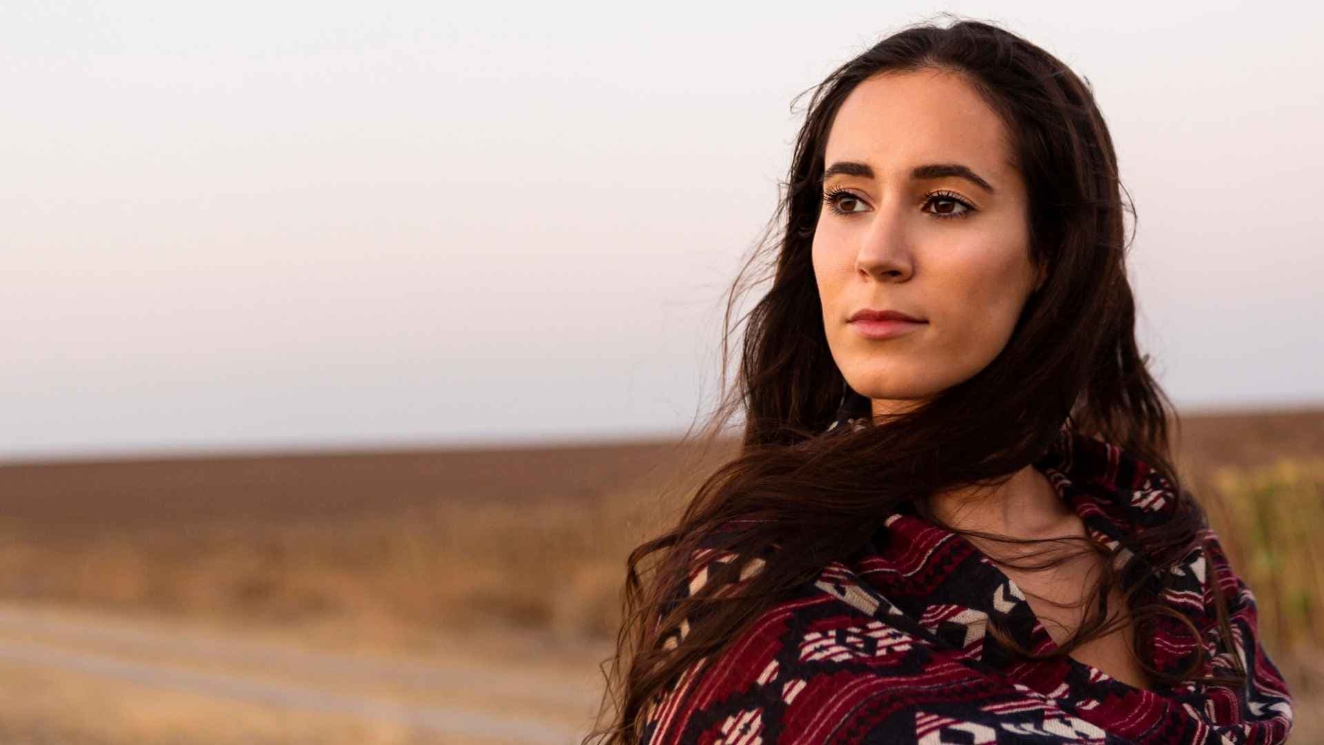 Portrait d’une femme regardant vers l’horizon dans un paysage naturel au coucher du soleil